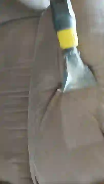 Proceso de limpieza profesional de un sofá tapizado con máquina de inyección y extracción